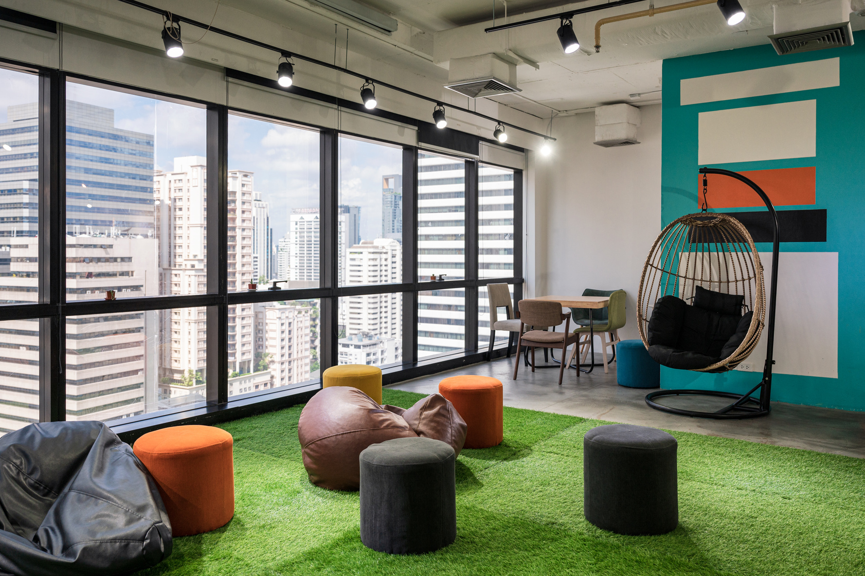 Creative room coworking space with cushions and chairs on artificial grass in office